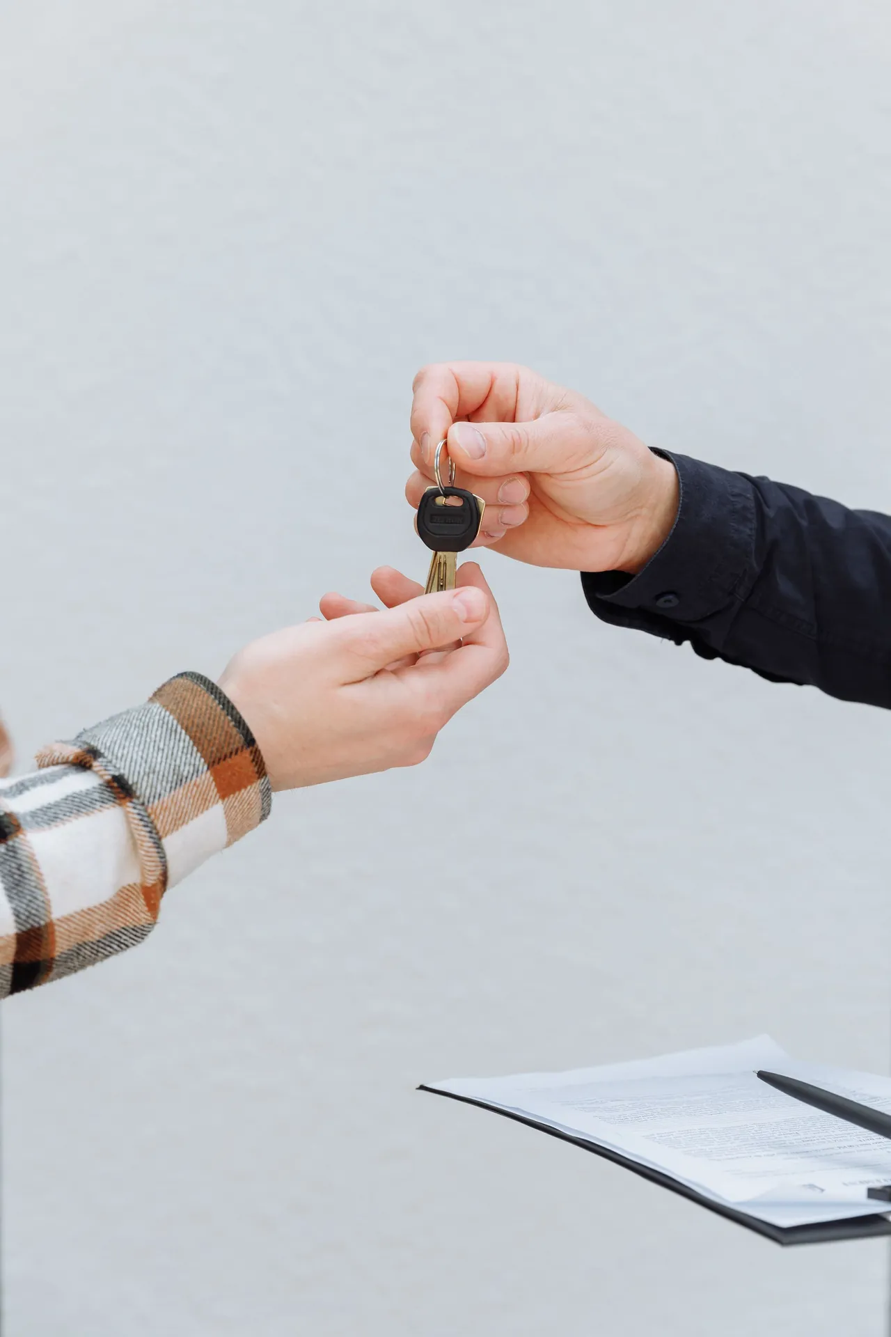 Hands exchanging vehicle keys during a transaction